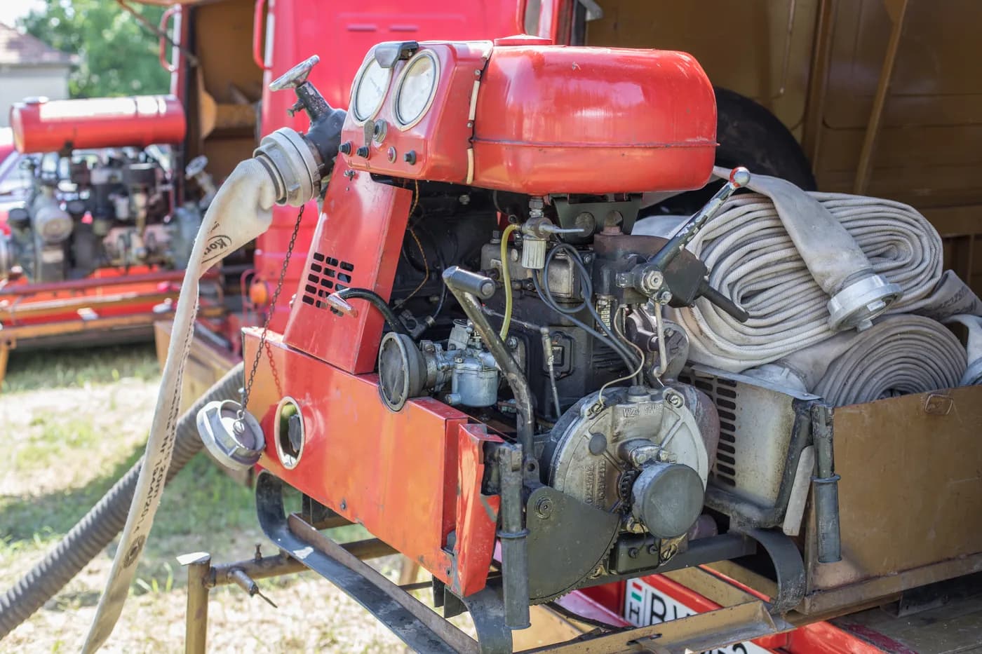 Portable fire fighting pump with a petrol engine, carrying frame and hose couplings